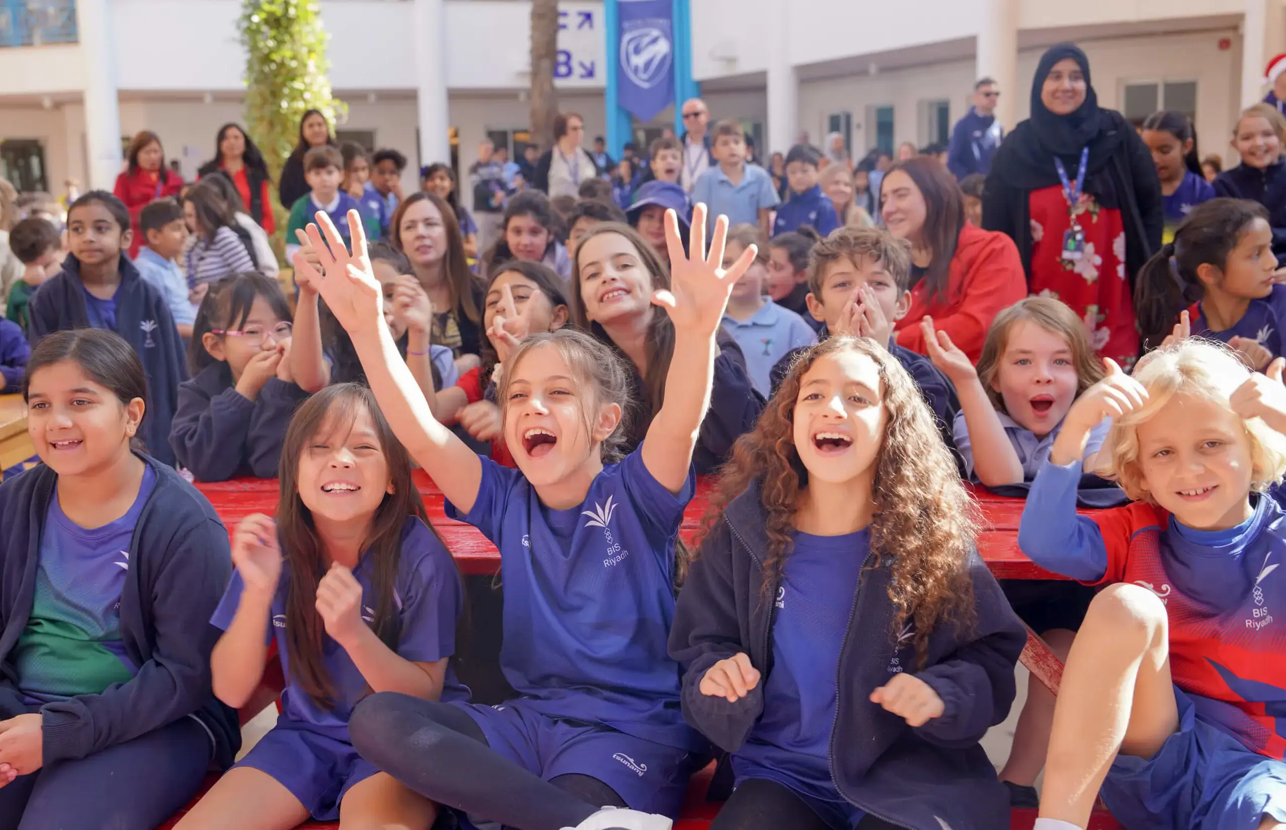 BISR Al Hamra students cheering at a school event.