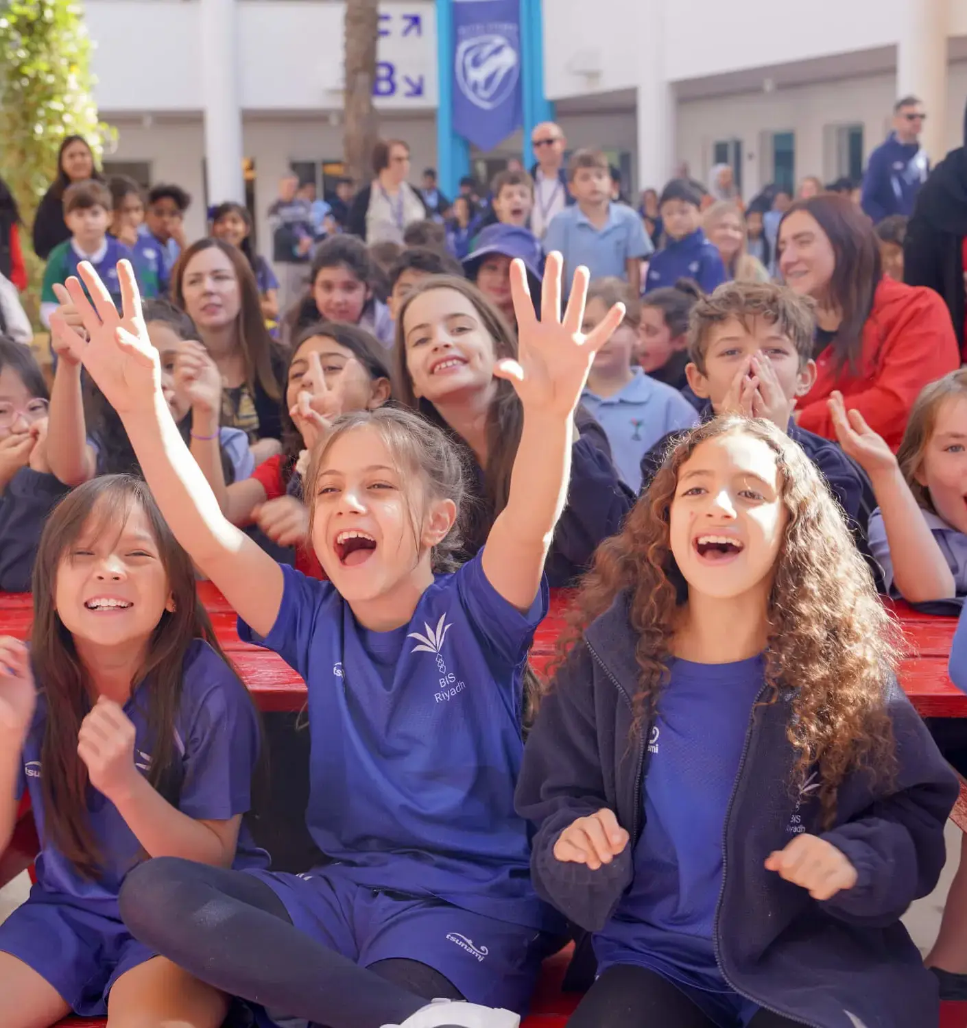 BISR Al Hamra students cheering at a school event.