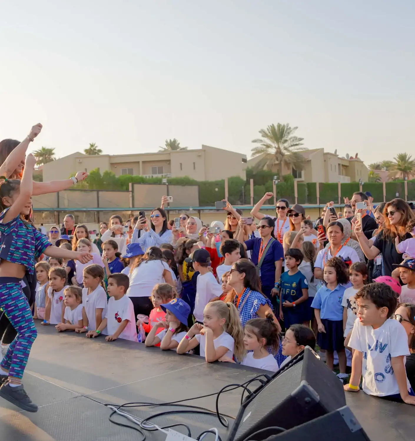BISR Al Hamra students watch a performance on stage at a school event.