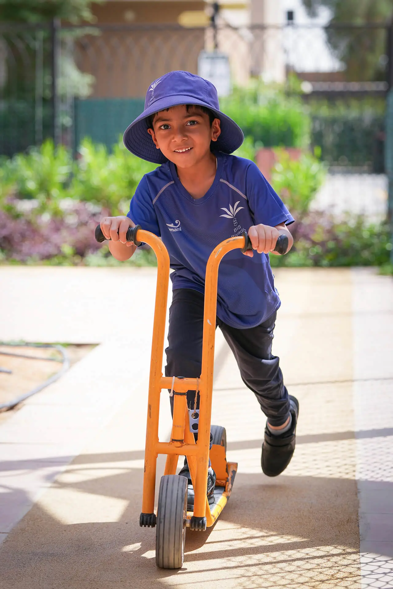 Pupil riding a scooter in the school grounds